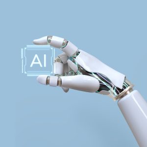 A white robotic hand holding a glowing microchip with the letters “AI” on it, symbolizing artificial intelligence technology and innovation, against a light blue background.